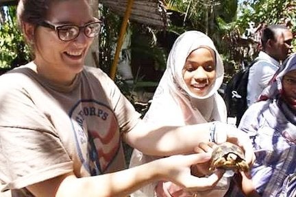 Bea Heiderman showing a turtle to a group of girls